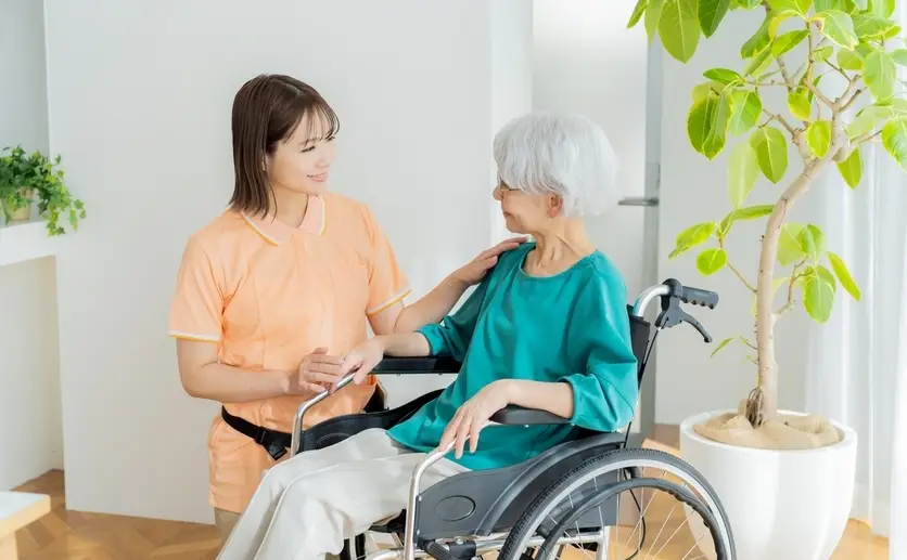 介護を受ける車いすの女性